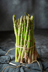 Bunch of fresh green asparagus on the table on the dark background 