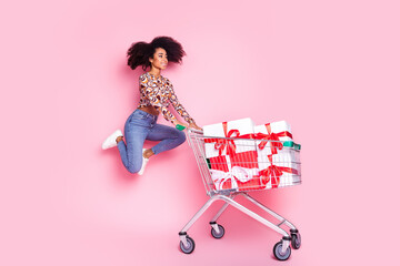 Full length photo of adorable positive girl wear print shirt buying presents walking supermarket...