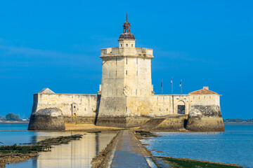 Exterior view of Fort Louvois fortress at low tide on a sunny day