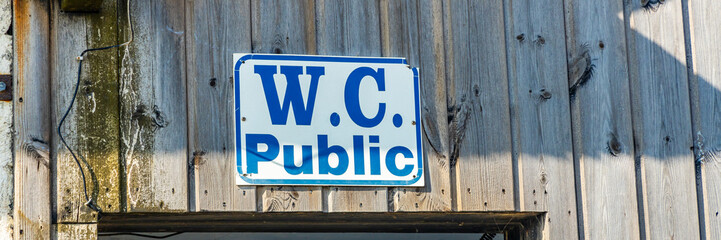 Public WC sign on a wooden wall in Oleron, France