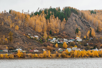 a village in the autumn yellowed mountains on the shore of the lake