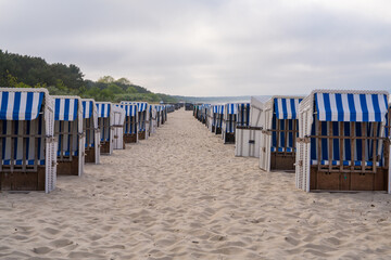 Sandy beach and traditional sun loungers at sunset, Northern Germany, on the Baltic Sea coast....