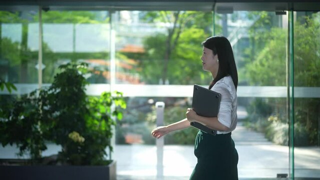 businesswoman walking with laptop