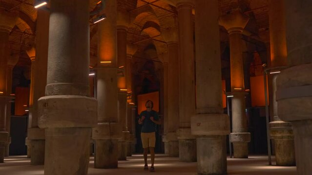 A young woman tours the ancient Cisterna of Istanbul, an underground marvel once filled with fresh water reserves, exploring its historic depths and serene ambiance. Slowmotion video.