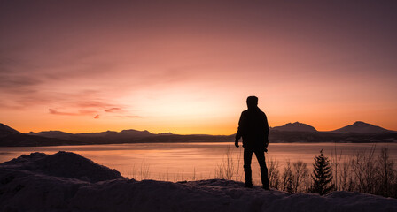 Silhouette of a man at sunset over the Norwegian Fjords