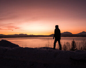 Fototapeta premium Silhouette of a man at sunset over the Norwegian Fjords