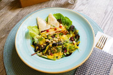 Burrata Mediterranean salad with pomegranate on a wooden table