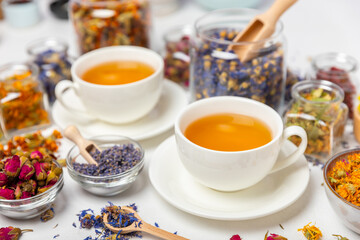 Assortment of dry herbal and berry tea and a cup of tea on a wooden background.Medicinal Healing herbs.Alternative medicine concept.Linden, calendula, cornflowers, marigold, tansy, tea rose.dry herbal