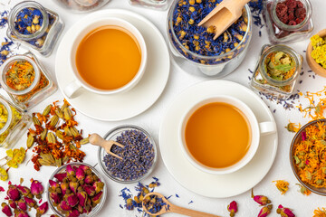 Assortment of dry herbal and berry tea and a cup of tea on a wooden background.Medicinal Healing herbs.Alternative medicine concept.Linden, calendula, cornflowers, marigold, tansy, tea rose.dry herbal