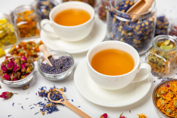 Assortment of dry herbal and berry tea and a cup of tea on a wooden background.Medicinal Healing herbs.Alternative medicine concept.Linden, calendula, cornflowers, marigold, tansy, tea rose.dry herbal