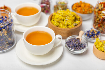 Assortment of dry herbal and berry tea and a cup of tea on a wooden background.Medicinal Healing herbs.Alternative medicine concept.Linden, calendula, cornflowers, marigold, tansy, tea rose.dry herbal