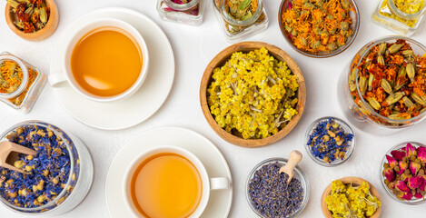 Assortment of dry herbal and berry tea and a cup of tea on a wooden background.Medicinal Healing herbs.Alternative medicine concept.Linden, calendula, cornflowers, marigold, tansy, tea rose.dry herbal