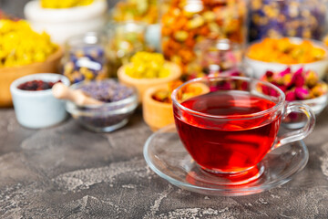 Assortment of dry herbal and berry tea and a cup of tea on a wooden background.Medicinal Healing herbs.Alternative medicine concept.Linden, calendula, cornflowers, marigold, tansy, tea rose.dry herbal