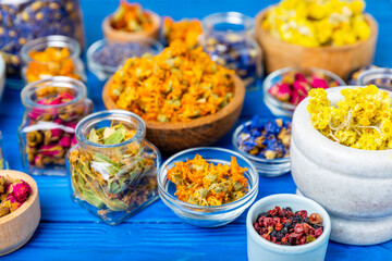 Assortment of dry herbal and berry tea on a wooden background. Tea party concept. medicinal herbs. Healing herbs.Alternative medicine.Linden, calendula, cornflowers, marigold, tansy, tea rose.