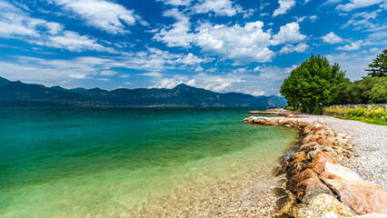 Scenic View of Lake Garda's East Shore with Wooden Pier and Clear Waters
