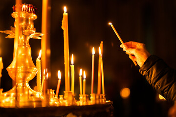 Many burning wax candles in the orthodox church or temple. Candles in a Christian Orthodox church background. Burning candles during church service. 