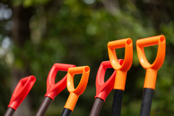 Garden shovels on a green background. Gardening tool. Garden shovel handles. Gardening concept. Set of plastic shovels.
