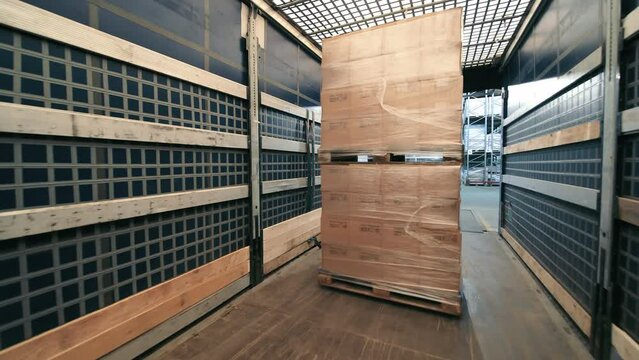 Warehouse worker moving pallet, A warehouse worker is captured in motion while moving a pallet with a pallet jack.