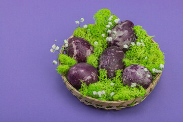 Marble Easter eggs, wooden basket, moss, gypsophila flowers. Festive concept, greeting card