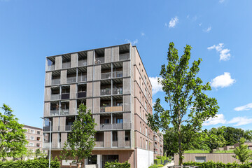Residential area with ecological and sustainable green residential buildings, low-energy houses with wooden facade, timber construction and green courtyard