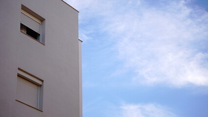 Fototapeta premium simple building facade with windows against cloudy sky