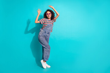Photo of positive cheerful girl dancing isolated cyan color background