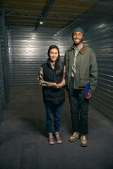 Joyous warehouse manager and pleased client inside storage unit