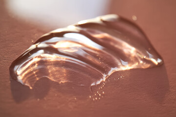 Beautiful volumetric drop of cosmetic product on a pink background.