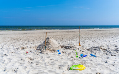 Shovels, toys on the sandy beach of the Baltic Sea. Vacation with children. Baby vacation