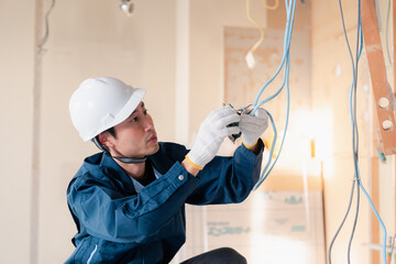 建築現場で配線工事をする電気工事士