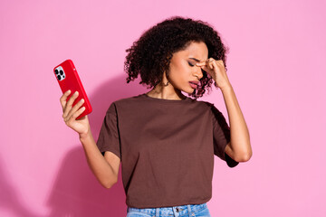 Photo of charming sad disappointed girl wear brown stylish clothes hold modern device isolated on...