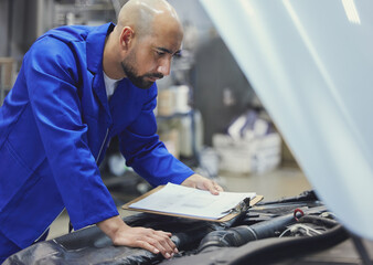 Mechanic, inspection or man with checklist in garage or service store for transportation industry....