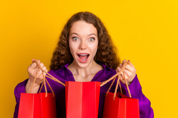 Photo portrait of lovely young lady peek interested hold shopping bags dressed stylish violet...