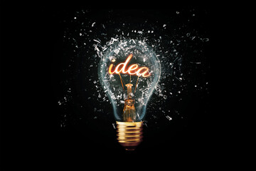Creative idea light bulb with Idea explodes with shards of glass on a dark background. Business, ideas and new thinking. Think Different. Go beyond what is possible. Marketing. Creative thinking
