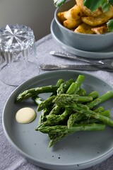 Zielone szparagi  na szarym talerzy