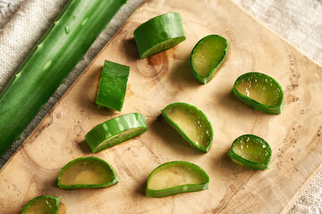 Fresh slices of aloe vera leaves on a wooden cutting board