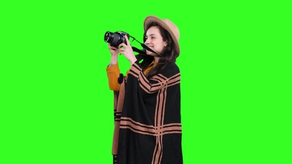 Happy stylish woman traveling and making photo by camera on the chroma key