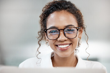 Portrait, smile and business woman in glasses on laptop in office for software development in startup. Face, reflection or happy professional entrepreneur, web designer or creative employee in Brazil