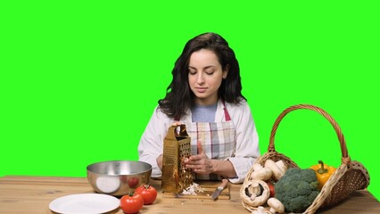 Young woman grating mushrooms and cutting her finger on the chroma key