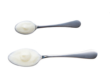 Metal spoon with yogurt isolated on a white background, top view.