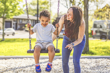 Playtime Moments. Mom With Her son Swinging Having Fun on the Playground Outside, Sharing Laughter...