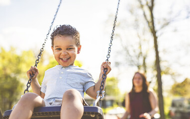 Playtime Moments. Mom With Her son Swinging Having Fun on the Playground Outside, Sharing Laughter...