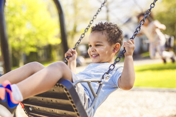 Happy child brother and sister on a swing. Happy kid on playground