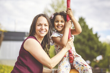 Playtime Moments. Mom With Her daughter Having Fun on the Playground Outside, Sharing Laughter and Joyful Bonding In Park Outdoors