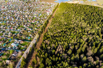 View from a high altitude of a village near a forest through which a gas clearing was cut for gasification