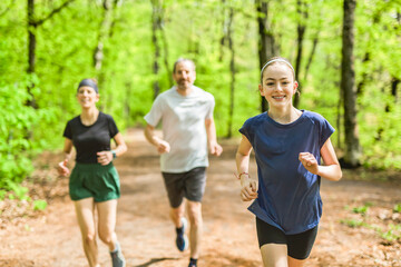 A Family exercising and jogging together at an outdoor park having great fun