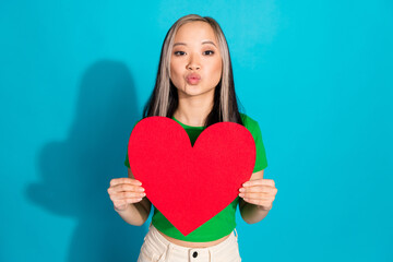 Photo of nice young girl paper heart kiss lips wear green t-shirt isolated on teal color background