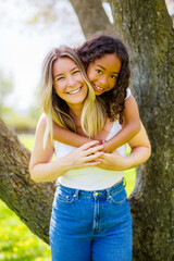 Fototapeta premium Black American child is playing with her mother while having a summer picnic in the public park.