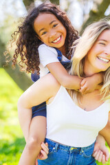 Fototapeta premium Black American child is playing with her mother while having a summer picnic in the public park.
