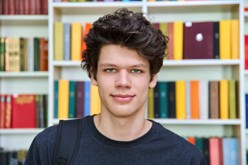 Headshot portrait of college student guy inside library of educational building